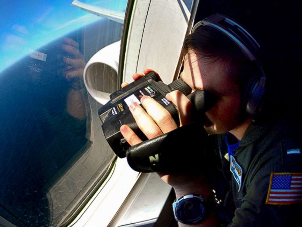 PHOTO: A U.S. Navy member uses binoculars from an aircraft searching for Argentinas missing ARA San Juan submarine in the Southern Atlantic, after leaving a base in Bahia Blanca, Argentina, Nov. 27, 2017. 