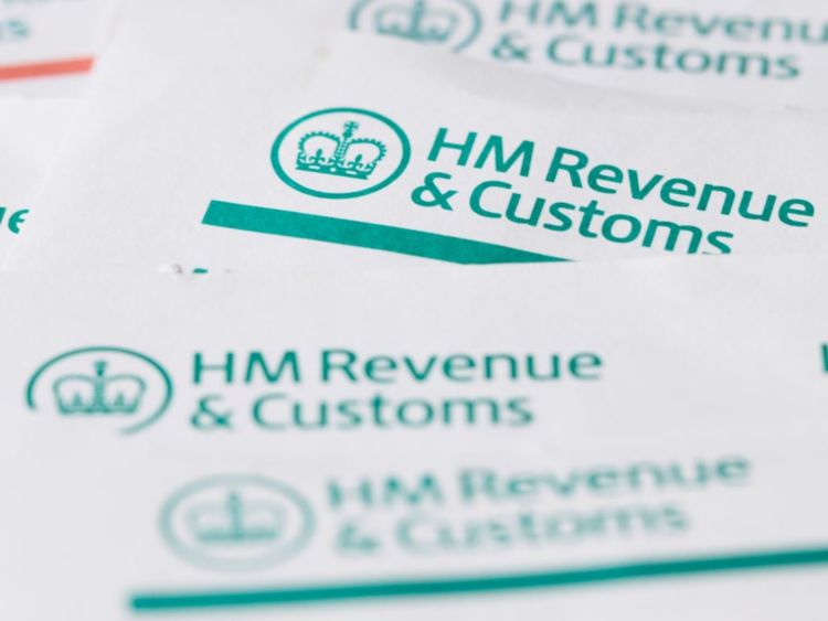 London, United Kingdom - July 6, 2016: HM Revenue and customs forms background with British currency coins. HMRC is the department of the UK government that is responsible for the collection of taxes.