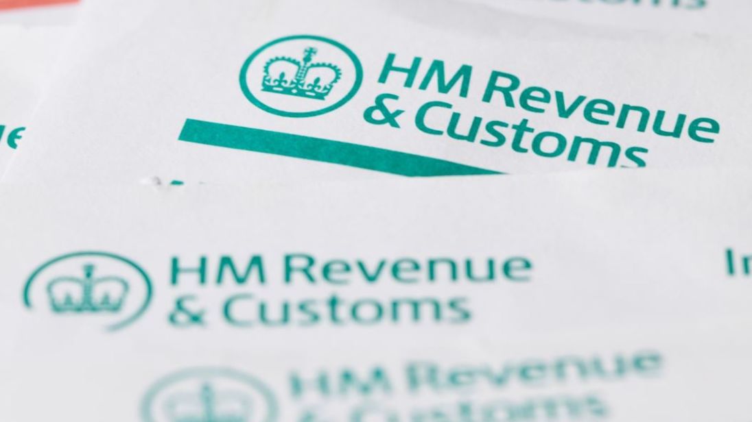 London, United Kingdom - July 6, 2016: HM Revenue and customs forms background with British currency coins. HMRC is the department of the UK government that is responsible for the collection of taxes.