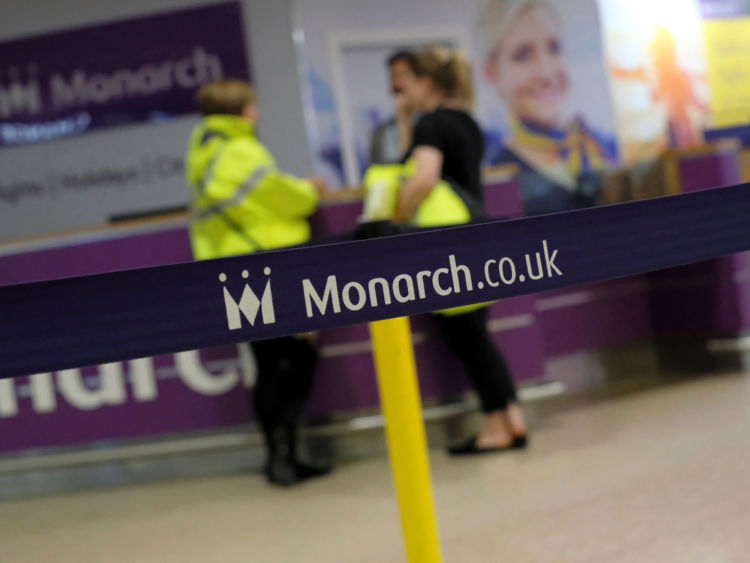 Airport staff speak by empty Monarch Airlines check-in desks after the airline ceased trading at Birmingham Airport, Britain October 2, 2017.