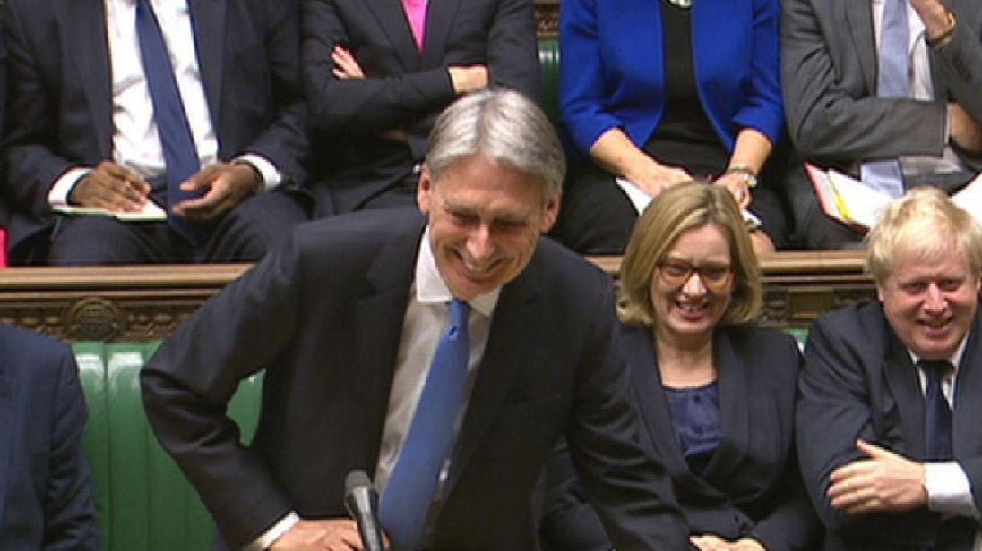 Theresa May passes Philip Hammond some cough sweets
