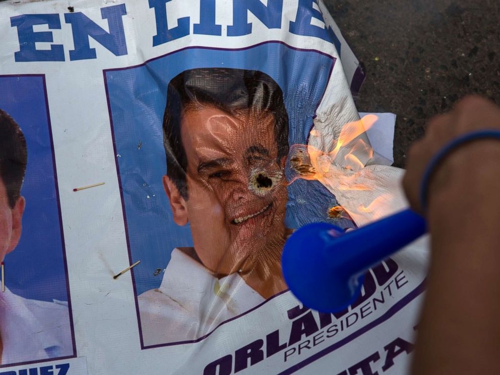 PHOTO: A banner promoting Honduran President Juan Orlando Hernandez burns after being set on fire by supporters of challenger Salvador Nasralla, during a protest march claiming electoral fraud, in Tegucigalpa, Honduras, Nov. 29, 2017. 