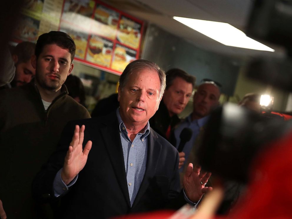 PHOTO: Doug Jones talks with reporters during a campaign stop at restaurant Chris Zs, Dec. 11, 2017, in Birmingham, Ala.