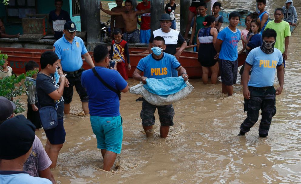 PHOTO: A Filipino policeman carries a body of a victim on floodwater in flood hit town of Salvador, Lanao del Norte province, Philippines, Dec. 23, 2017. 
