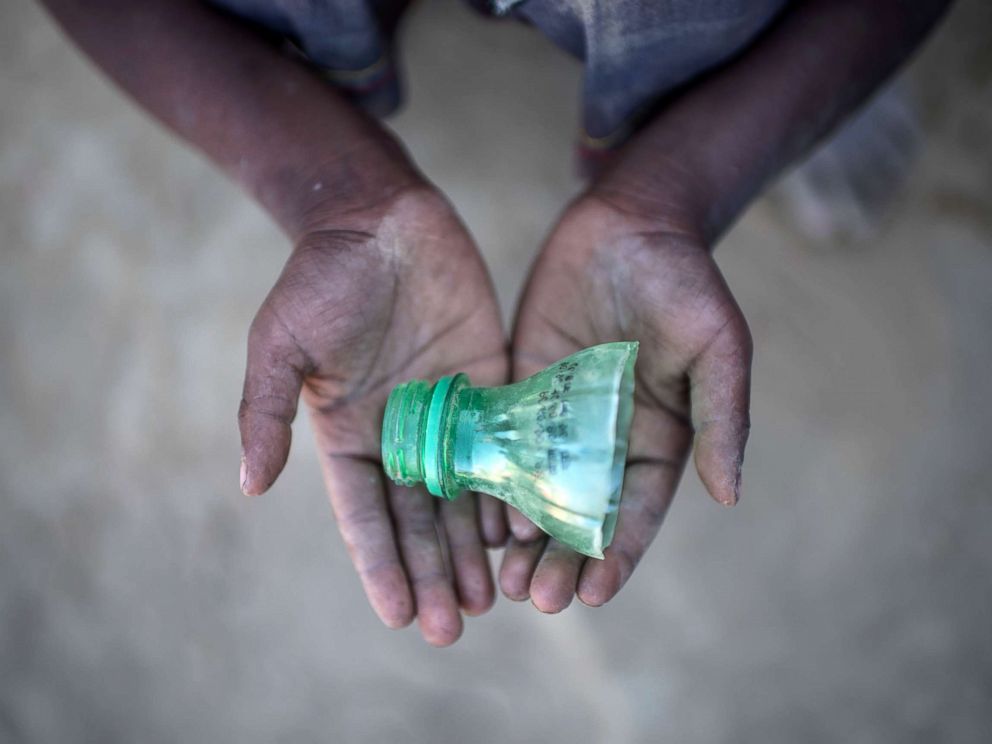 PHOTO: Rohingya migrant boy Shahidul Amin (5), who arrived in Bangladesh in September, holds a part of a bottle that he uses to play in the sand at the Thankhali refugee camp in Coxs Bazar, on Dec. 2, 2017. 