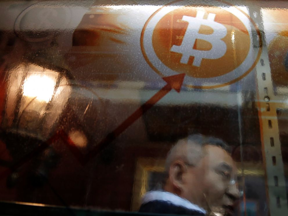 FILE - In this Friday, Dec. 8, 2017, file photo, a man uses a Bitcoin ATM in Hong Kong. On Thursday, Jan. 11, 2018, the value of numerous forms of digital currency tumbled after South Korea, a hotbed for currencies like bitcoin, said it was weighing 