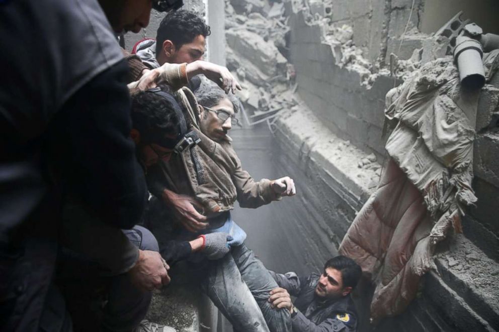 PHOTO: Civil defense help a man from a shelter in the besieged town of Douma in eastern Ghouta in Damascus, Syria, on Feb. 22, 2018. 