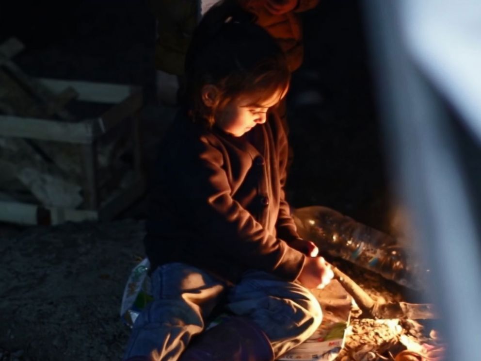 PHOTO: In Lesbos Moria refugee camp, children gather around fires to keep warm.