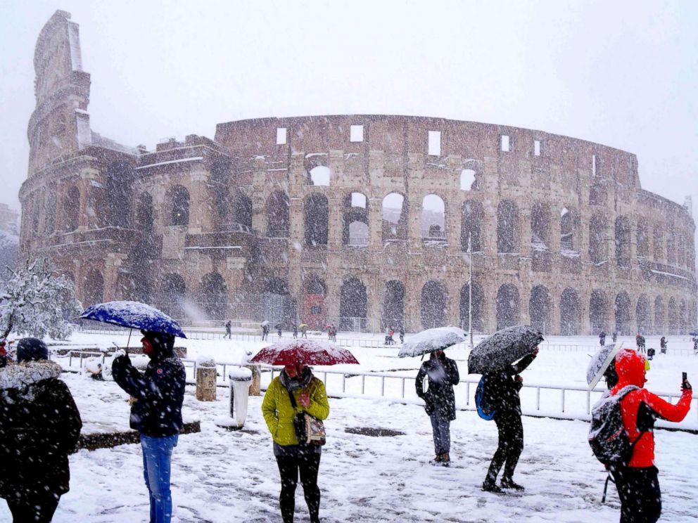 PHOTO: Tourists take pictures of the ancient Colosseum during a snowfall in Rome, Feb. 26, 2018.