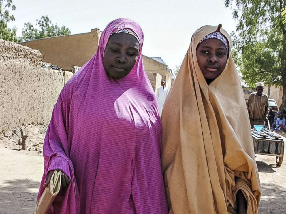 PHOTO: A girl, right, released by Boko Haram walks with her mother in Dapchi, Nigeria on March 21, 2018, after Boko Haram Islamists who kidnapped 110 schoolgirls just over a month ago returned 101 of the students to the town, the government said. 