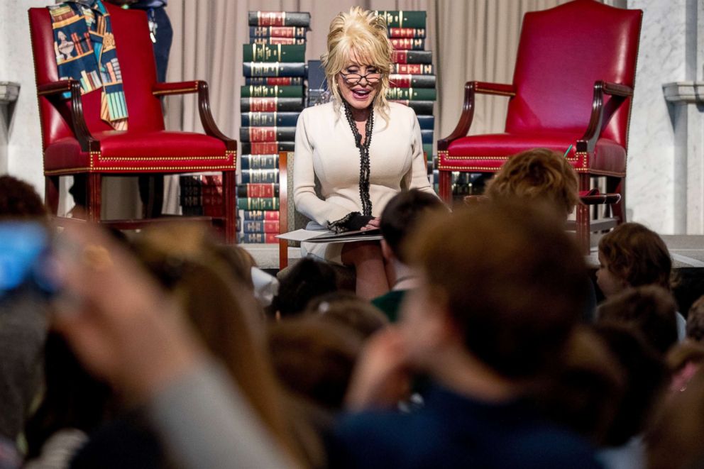 PHOTO: Dolly Parton reads her book Coat of Many Colors, to children as she makes it the 100 millionth book that Imagination Library donates to the Library of Congress collection at the Library of Congress, Feb. 27, 2018, in Washington.