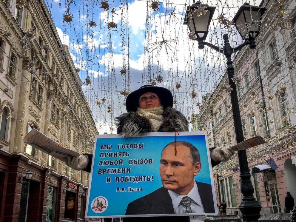 PHOTO: An activist distributes election leaflets in support of presidential candidate, President Vladimir Putin on a street in downtown Moscow, March 16, 2018.