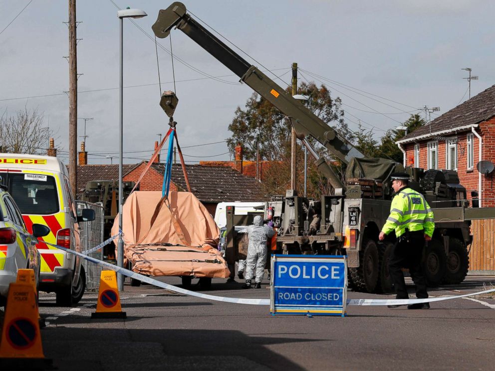 PHOTO: British Military personnel wearing protective coveralls work to remove a vehicle connected to the March 4 nerve agent attack in Salisbury, from a residential street in Gillingham, southeast England on March 14, 2018. <p itemprop=