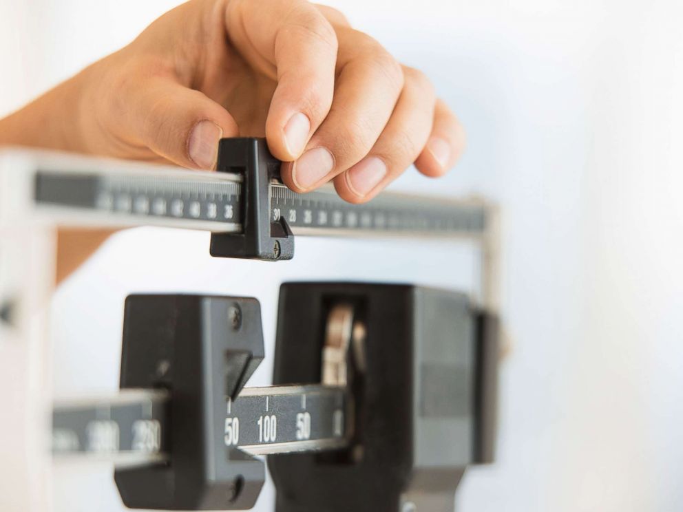 PHOTO: Stock photo of a person using a scale to weigh themselves. 