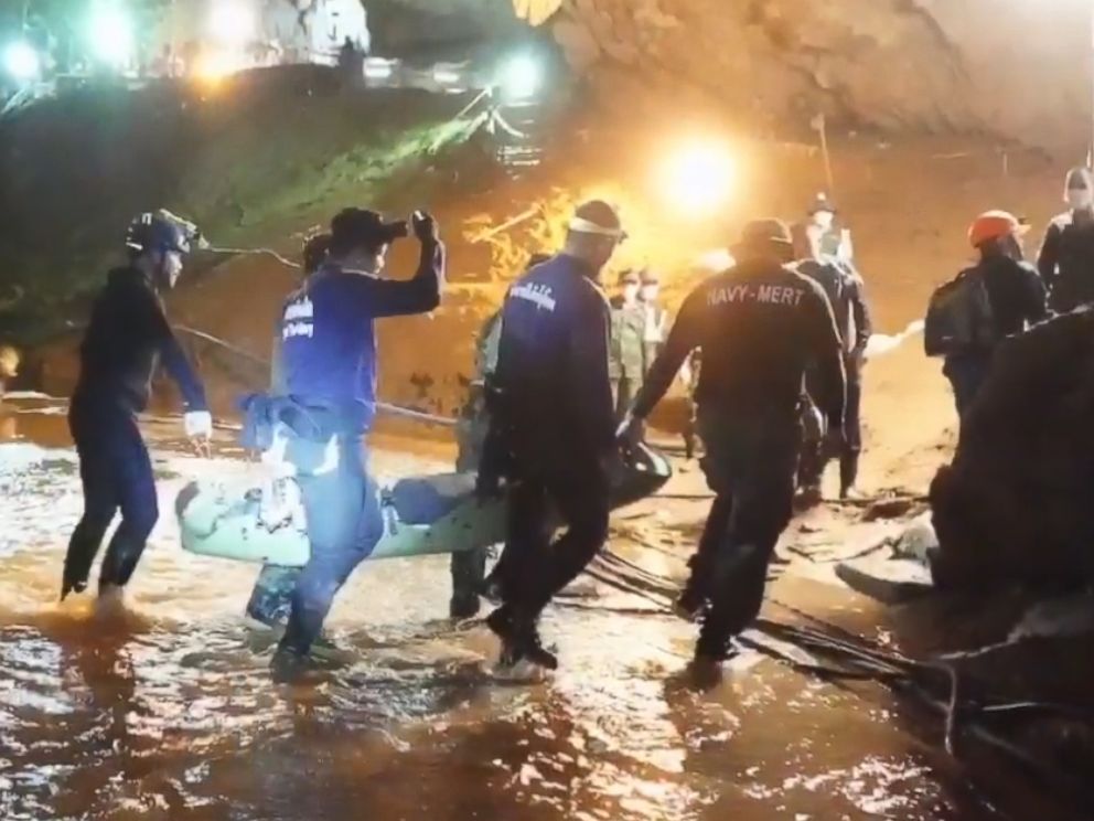PHOTO: One of the rescued boys is carried by six rescuers across ankle-high stream of water to medics inside the cave for immediate treatment. 
